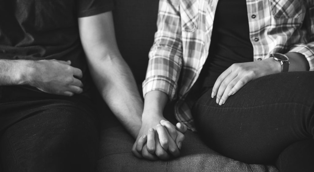 Closeup of couple holding hands